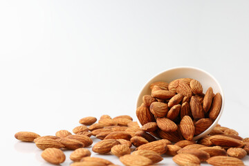 Almonds nuts in white bowl isolated on a white background with copy space is useful to help neutralize free radicals, help prevent Alzheimer's disease, helping repair the wear and tear on the body.