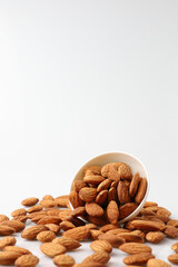 Almonds nuts in white bowl isolated on a white background with copy space is useful to help neutralize free radicals, help prevent Alzheimer's disease, helping repair the wear and tear on the body.