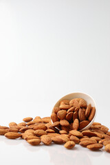 Almonds nuts in white bowl isolated on a white background with copy space is useful to help neutralize free radicals, help prevent Alzheimer's disease, helping repair the wear and tear on the body.