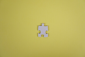 one Jigsaw puzzle piece on yellow background concept copy space