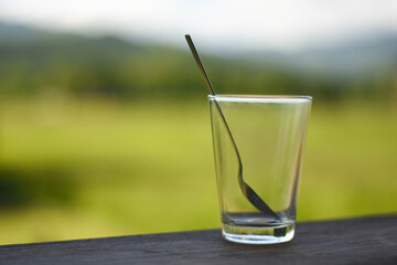 Blurred spoon in empty glass with burred background.