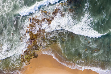 Top down view waves breaking against rugged coastline - Dudley Beach - Newcastle NSW Australia