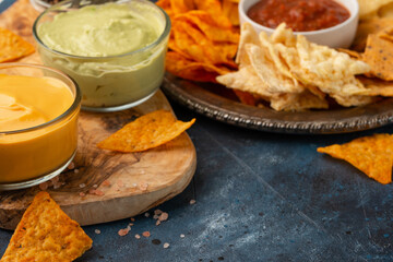Potato chips, various snacks, pita chips, with a dip on a blue background, rest and get-togethers for football