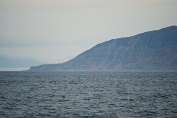 Steep shores of the Kuril Islands. Islands in the sea. Fall.