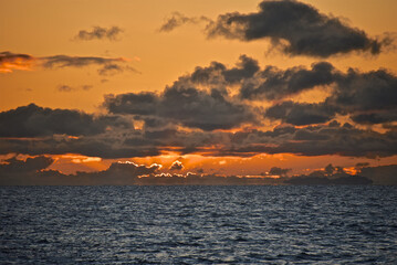 Autumn red sunset over the cold polar sea. Red clouds, illuminated by the cold sun, over the horizon. Photo from the side of the ship.