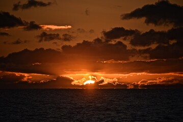 Autumn red sunset over the cold polar sea. Red clouds, illuminated by the cold sun, over the horizon. Photo from the side of the ship.