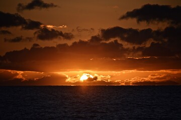 Autumn red sunset over the cold polar sea. Red clouds, illuminated by the cold sun, over the horizon. Photo from the side of the ship.