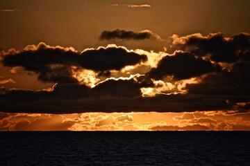 Autumn red sunset over the cold polar sea. Red clouds, illuminated by the cold sun, over the horizon. Photo from the side of the ship.