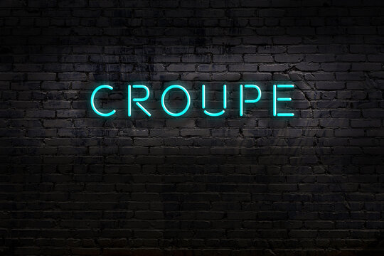 Night view of neon sign on brick wall with inscription croupe