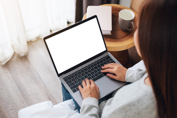 Top view mockup image of a woman working and typing on laptop computer with blank screen while...