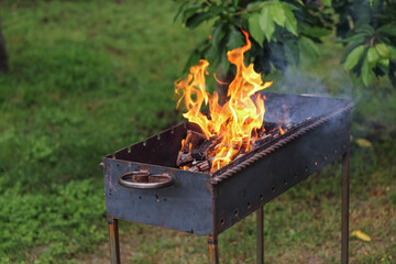 Burning firewood in a barbecue for cooking barbecue outdoor