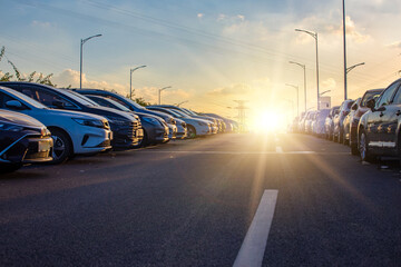 A roadside parking lot full of cars at sunset