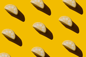 Pattern of tasty marshmallows with hard shadows on a yellow background.