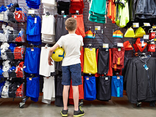 Boy with ball in football clothing store