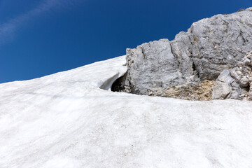 The last snow in the alps. Dirty snow on the rocks