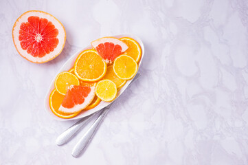 Plate with citrus fresh fruits on a white background. High in antioxidants, vitamins, dietary fibre and anthocaynins.