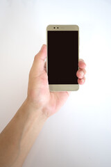 Middle aged man holding smartphone with black screen in one hand.