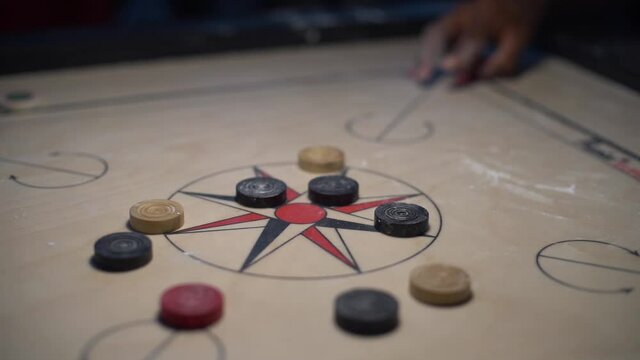 close up at child playing carom slow motion, carom board, Indian traditional games