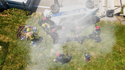 Top view of firefighters trying to release man in the crashed car.