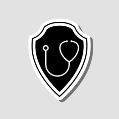 Shield and illustration of a medical stethoscope on it sticker isolated on gray background