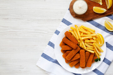Homemade Fish Sticks and Fries with Tartar Sauce on a white wooden background, top view. Flat lay,...