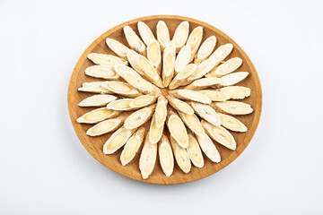 Astragalus membranaceus tablets on a plate on white background