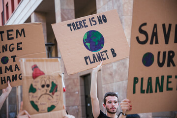 Group of young people at a demonstration for the environment - Young millennials protest at a procession to save the planet with slogans and drawn in the sign - Concept of manifestation - 364042855