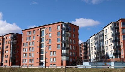 Red and white modern apartment buildings iclose to services. Affordable living for singles and families. Scandinavian architecture. Photo is taken in Espoo, Finland.