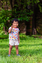 Playful Pretty Indian girl child/infant playing outdoors with nice environmental background