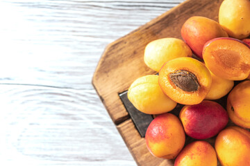 Fototapeta na wymiar Ripe fresh apricots on a wooden background. Summer fruit concept. Rustic style. Free space for your text.