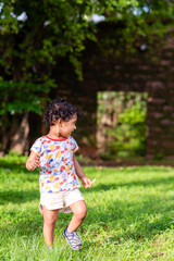 Playful Pretty Indian girl child/infant playing outdoors with nice environmental background