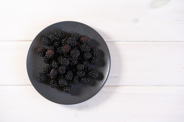Fresh blackberry on a dark plate