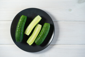 Fresh cucumbers on a dark plate