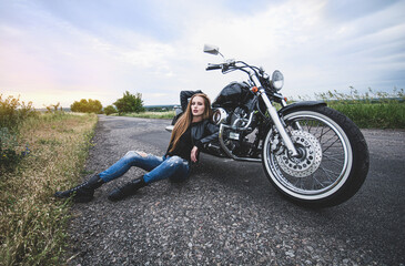Fototapeta na wymiar Beautiful girl biker sitting near the motorcycle.