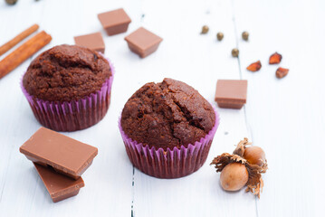 chocolate muffins with hazelnuts on white wooden