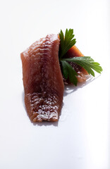 anchovy seasoned close-up on white background with a green detail