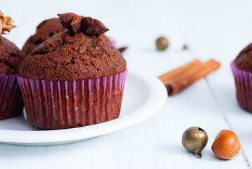 chocolate muffins with hazelnuts on white wooden