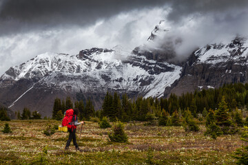 Female Backpacker Hiking in Canadian Rockies during a cloudy day. Taken near Banff, boarder of...