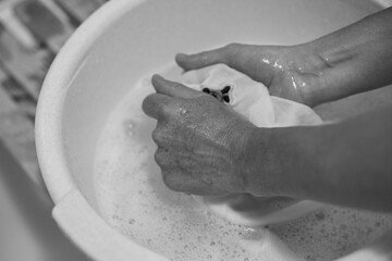 a woman washes clothes in a basin