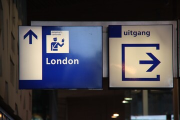 Blue and white direction sign to the passport control to london at Rotterdam station for Eurostar.