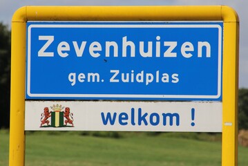 Blue and white sign of the urban area named Zevenhuizen in the Municipality of Zuidplas .