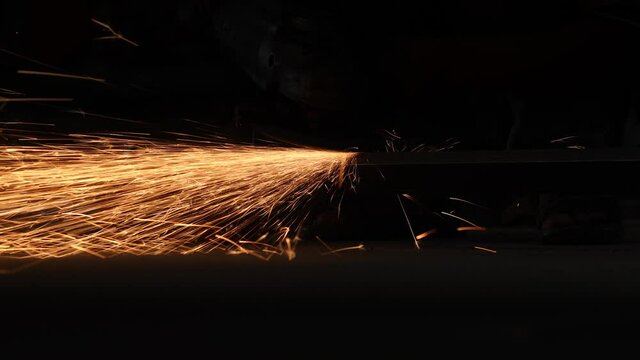 Worker grinding metal, metal grinding machine with sparks, metal sawing. Super slow motion