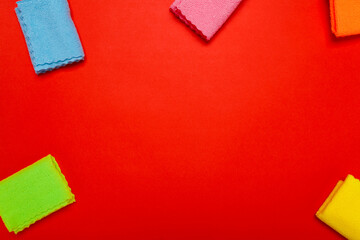 rags for cleaning. rags of different colors on a red background. copyspace