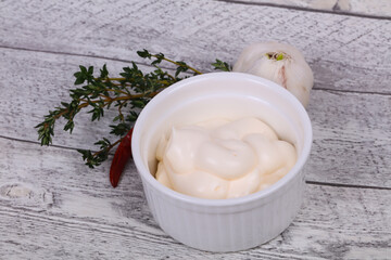 Mayonnaise sauce in the white bowl served thyme and garlic