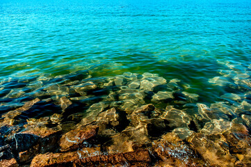 Klares Wasser auf dem See mit Steinen am Boden
