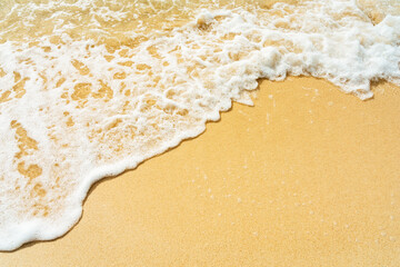 Soft ocean wave on clean sandy beach.