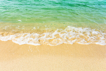 Soft ocean wave on clean sandy beach.