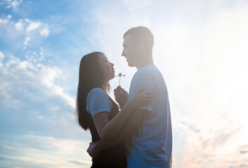 International young beautiful couple in love on the background of the Sunny sky.