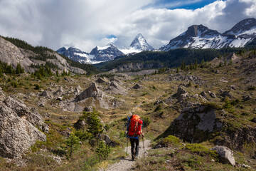 Fototapeta premium Adventure Backpacking in the Iconic Mt Assiniboine Provincial Park near Banff, Alberta, Canada. Girl Hiker with Canadian Mountain Landscape in Background.