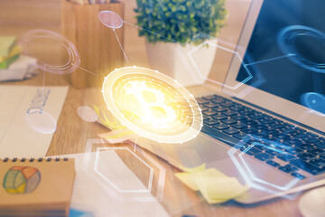 Multi exposure of blockchain theme hologram and table with computer background. Concept of bitcoin crypto currency.